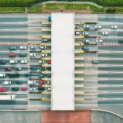 Widok z lotu ptaka na szlabany autostradowe z kolejkami samochodów i ciężarówek.
