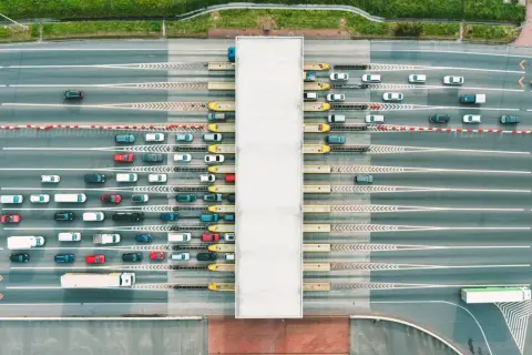 Widok z lotu ptaka na szlabany autostradowe z kolejkami samochodów i ciężarówek.