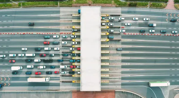 Widok z lotu ptaka na szlabany autostradowe z kolejkami samochodów i ciężarówek.