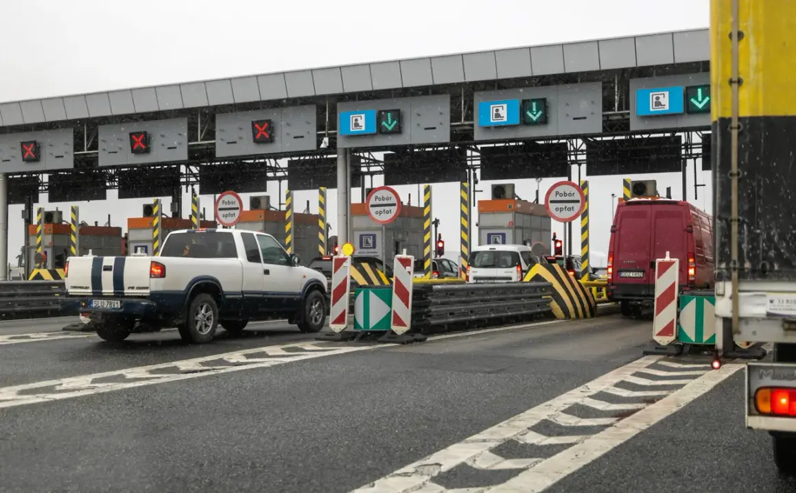 Autostrada z bramkami, znaki "Pobór opłat", czerwone krzyżyki i zielone strzałki nad pasami ruchu.